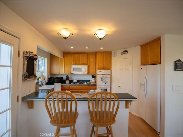 406 Delle Dr, Crestline, CA 92325 - kitchen featuring a sink, dark countertops, white appliances, and a peninsula