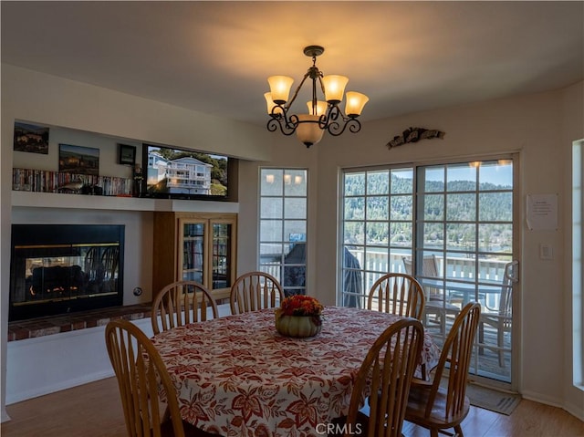 406 Delle Dr, Crestline, CA 92325 - dining area featuring a multi sided fireplace, a notable chandelier, and wood finished floors