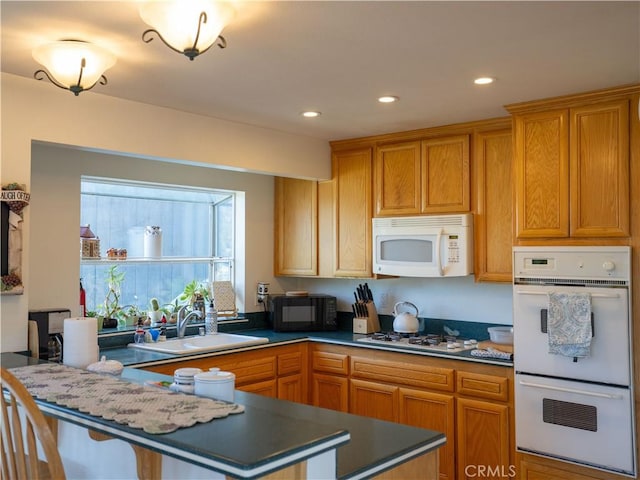 406 Delle Dr, Crestline, CA 92325 - kitchen with recessed lighting, white appliances, a peninsula, dark countertops, and a sink