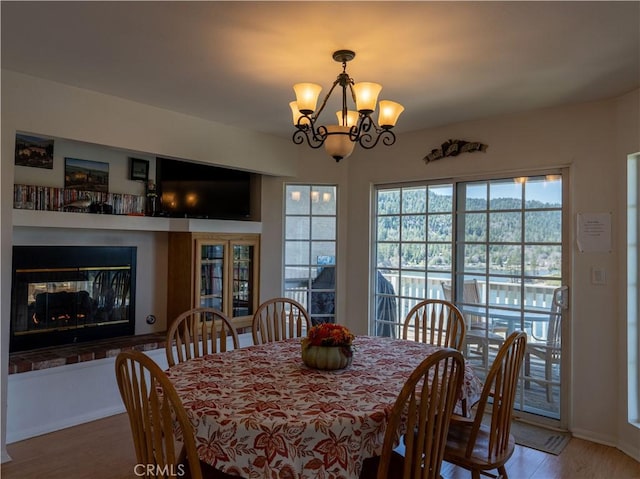 406 Delle Dr, Crestline, CA 92325 - dining space featuring wood finished floors, a notable chandelier, and a multi sided fireplace