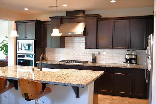 1019 El Molino Ave, Clovis, CA 93619 - kitchen with tasteful backsplash, visible vents, a sink, a breakfast bar, and stainless steel appliances