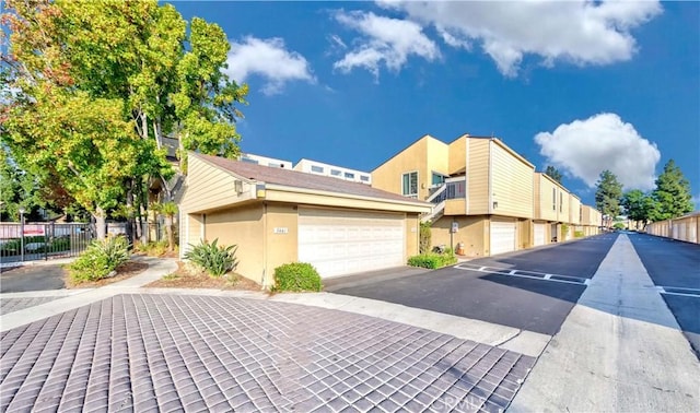 exterior space with a garage, stucco siding, and fence