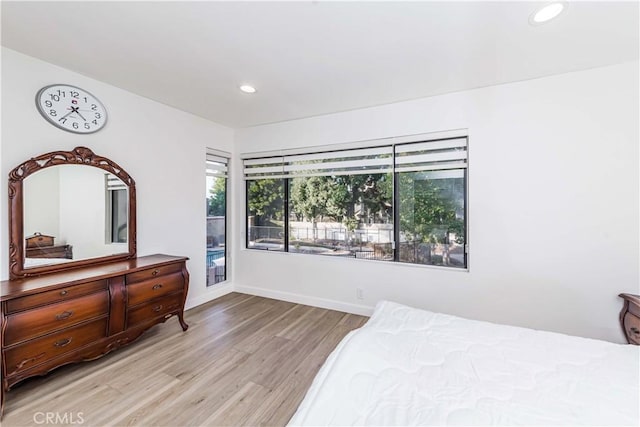 bedroom with baseboards, multiple windows, recessed lighting, and light wood finished floors