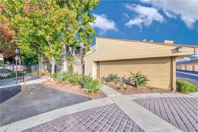 exterior space featuring stucco siding and fence