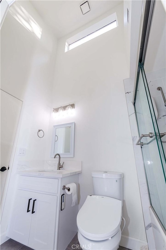 full bathroom featuring a towering ceiling, vanity, and toilet
