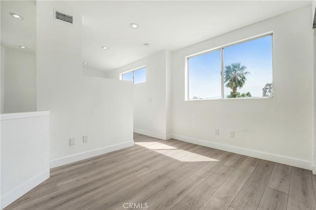 unfurnished room featuring baseboards, recessed lighting, wood finished floors, and visible vents