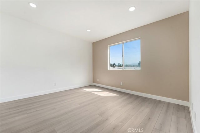 unfurnished room with recessed lighting, baseboards, and light wood finished floors