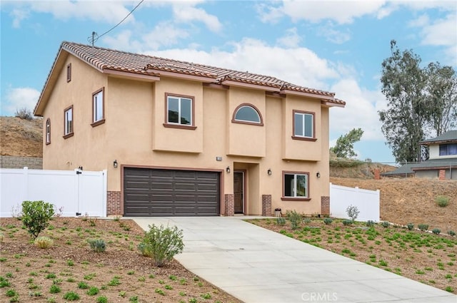 view of front of house with concrete driveway, stucco siding, an attached garage, a tiled roof, and fence