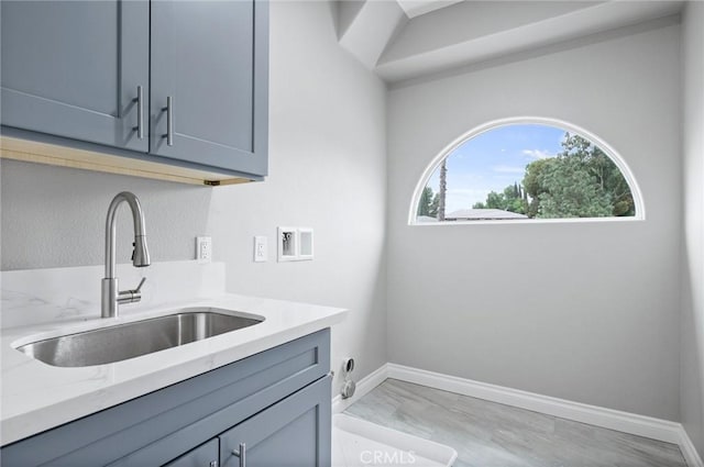 laundry area with baseboards, a sink, hookup for a washing machine, and cabinet space