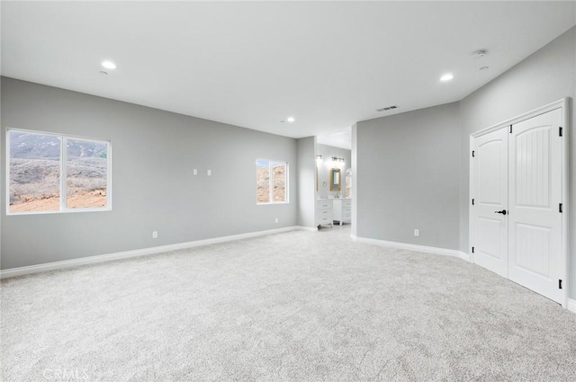 spare room with recessed lighting, carpet flooring, visible vents, and baseboards