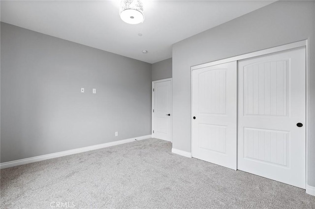 unfurnished bedroom with carpet flooring, a closet, and baseboards