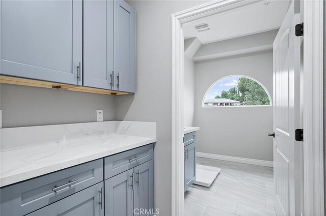 laundry area with baseboards and visible vents