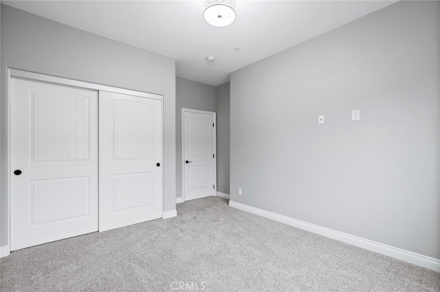 unfurnished bedroom featuring a closet, baseboards, and carpet