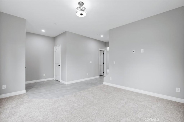 carpeted spare room featuring baseboards and recessed lighting