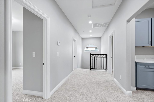 hallway featuring recessed lighting, visible vents, light colored carpet, and baseboards