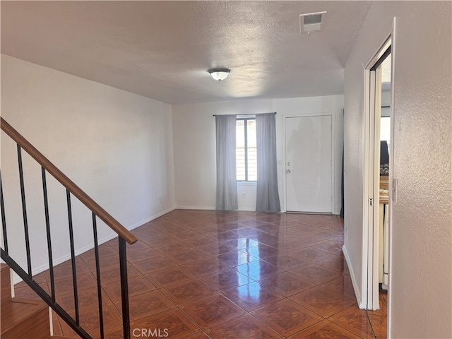 9208 Citrus Ave Unit C, Fontana, CA 92335 - unfurnished room with a textured ceiling, visible vents, baseboards, and dark tile patterned flooring