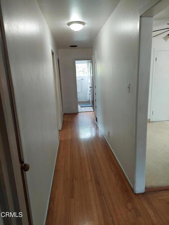 hall featuring baseboards and wood finished floors