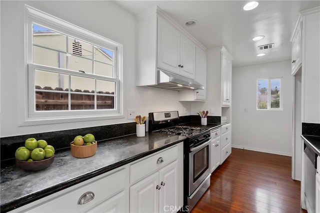 kitchen with visible vents, dark countertops, under cabinet range hood, white cabinetry, and stainless steel appliances