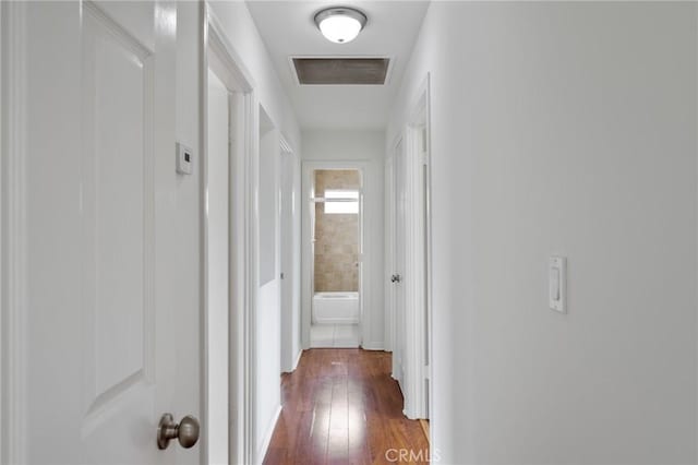 hallway featuring visible vents and dark wood-style floors