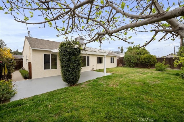 rear view of property with a patio area, a fenced backyard, a lawn, and stucco siding
