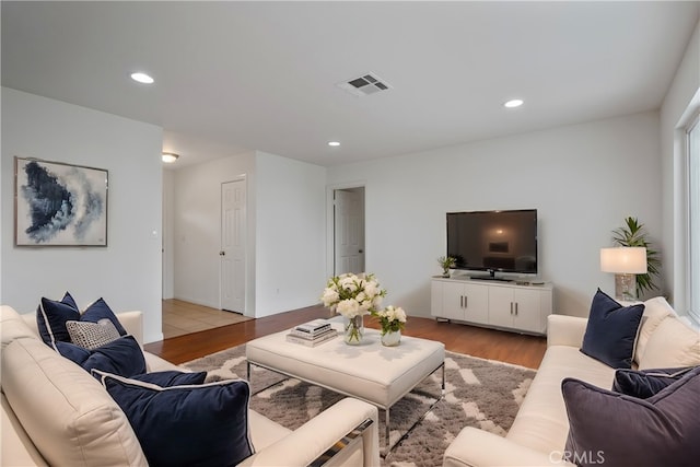 living area with visible vents, light wood-type flooring, and recessed lighting