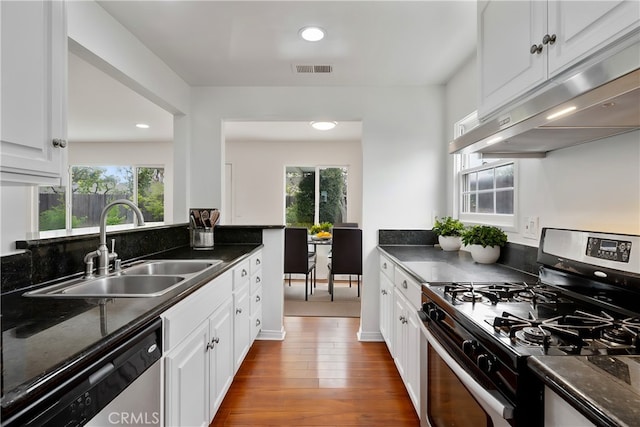 kitchen featuring a wealth of natural light, under cabinet range hood, visible vents, appliances with stainless steel finishes, and a sink