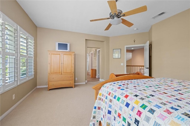 bedroom with light colored carpet, baseboards, a ceiling fan, and ensuite bathroom