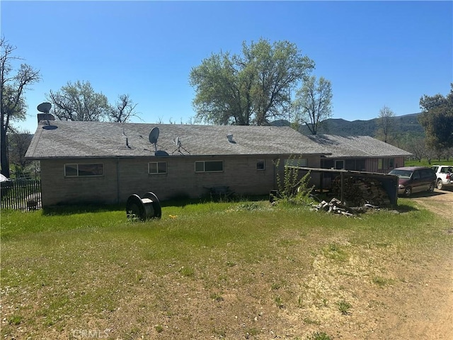 back of house with fence and a lawn