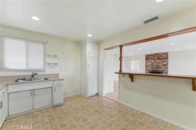 1114 Stovall Ave, La Puente, CA 91745 - kitchen featuring a sink, light floors, white cabinetry, visible vents, and recessed lighting