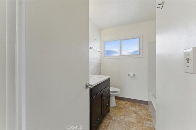 1114 Stovall Ave, La Puente, CA 91745 - full bath with stone finish floor, toilet, vanity, baseboards, and walk in shower