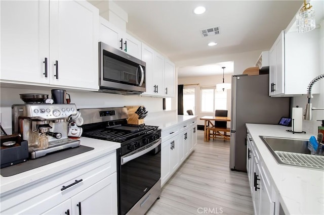45522 Andale Ave, Lancaster, CA 93535 - kitchen featuring stainless steel appliances, white cabinetry, light wood finished floors, recessed lighting, and light stone counters