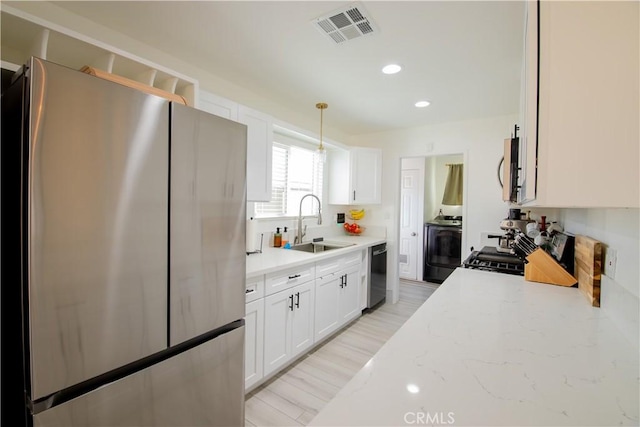45522 Andale Ave, Lancaster, CA 93535 - kitchen with appliances with stainless steel finishes, a sink, white cabinetry, washer / dryer, and recessed lighting