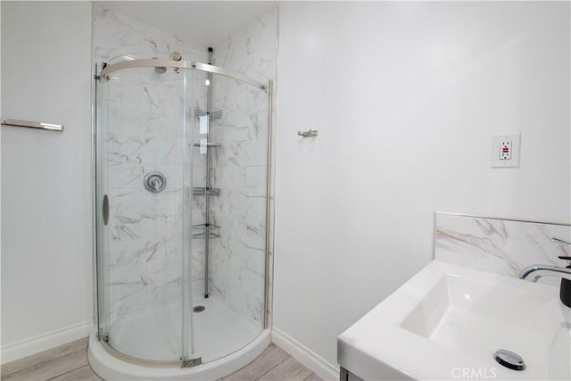 45522 Andale Ave, Lancaster, CA 93535 - full bath featuring a sink, a marble finish shower, baseboards, and wood finished floors
