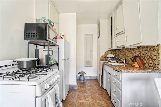 kitchen featuring tasteful backsplash, a sink, white range with gas stovetop, and white cabinets