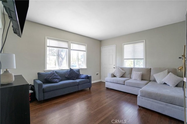living room featuring dark wood-type flooring and baseboards