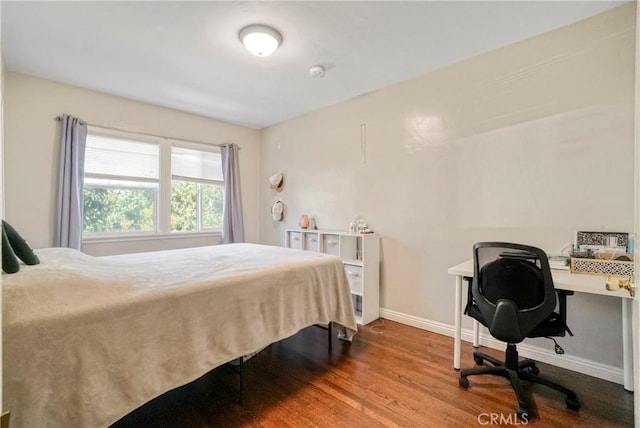bedroom with baseboards and wood finished floors