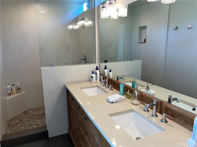 full bathroom featuring double vanity, a sink, a walk in shower, and tile patterned flooring