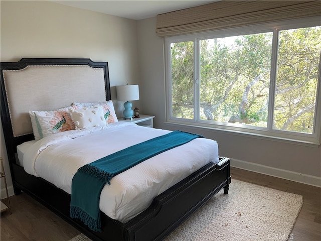 bedroom with baseboards and wood finished floors