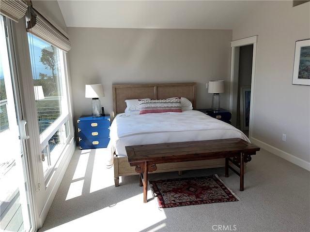 carpeted bedroom featuring baseboards and vaulted ceiling
