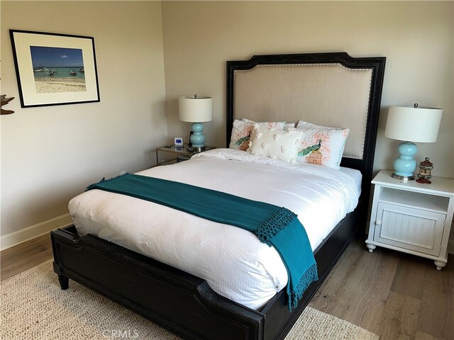 bedroom with baseboards and wood finished floors