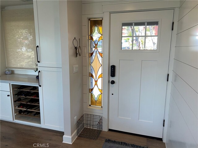 doorway to outside featuring dark wood finished floors and beverage cooler