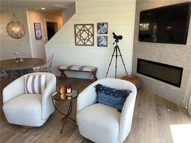 living area with recessed lighting, wood finished floors, and a tile fireplace
