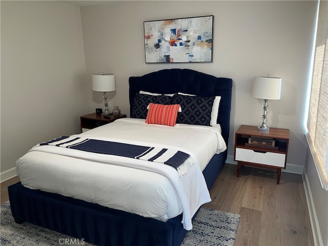 bedroom featuring baseboards and wood finished floors