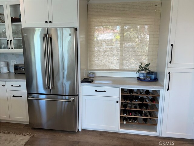 kitchen featuring freestanding refrigerator, white cabinets, and glass insert cabinets
