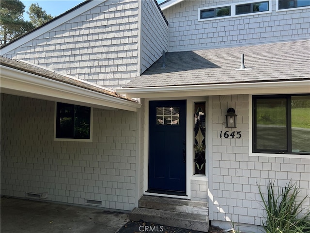 doorway to property featuring crawl space and a shingled roof