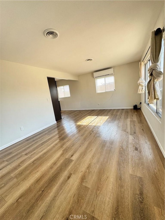 26659 6th St, Highland, CA 92346 - spare room with an AC wall unit, wood finished floors, and baseboards