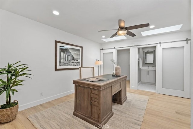 625 Calle Miguel, San Clemente, CA 92672 - home office with a barn door, light wood finished floors, ceiling fan, a skylight, and recessed lighting
