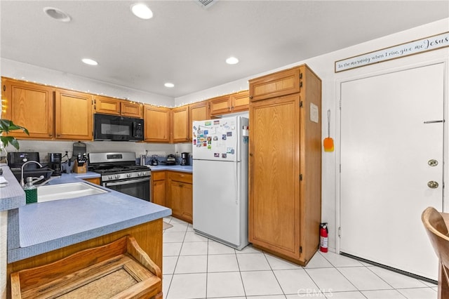 1509 Trinette Dr, Beaumont, CA 92223 - kitchen with stainless steel range with gas cooktop, freestanding refrigerator, black microwave, a sink, and brown cabinets