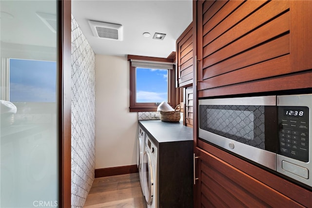 bathroom with baseboards, wood finished floors, and visible vents