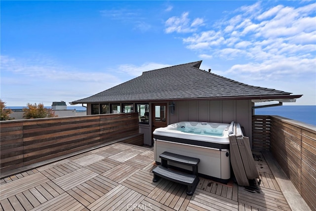 wooden terrace with a water view and a hot tub
